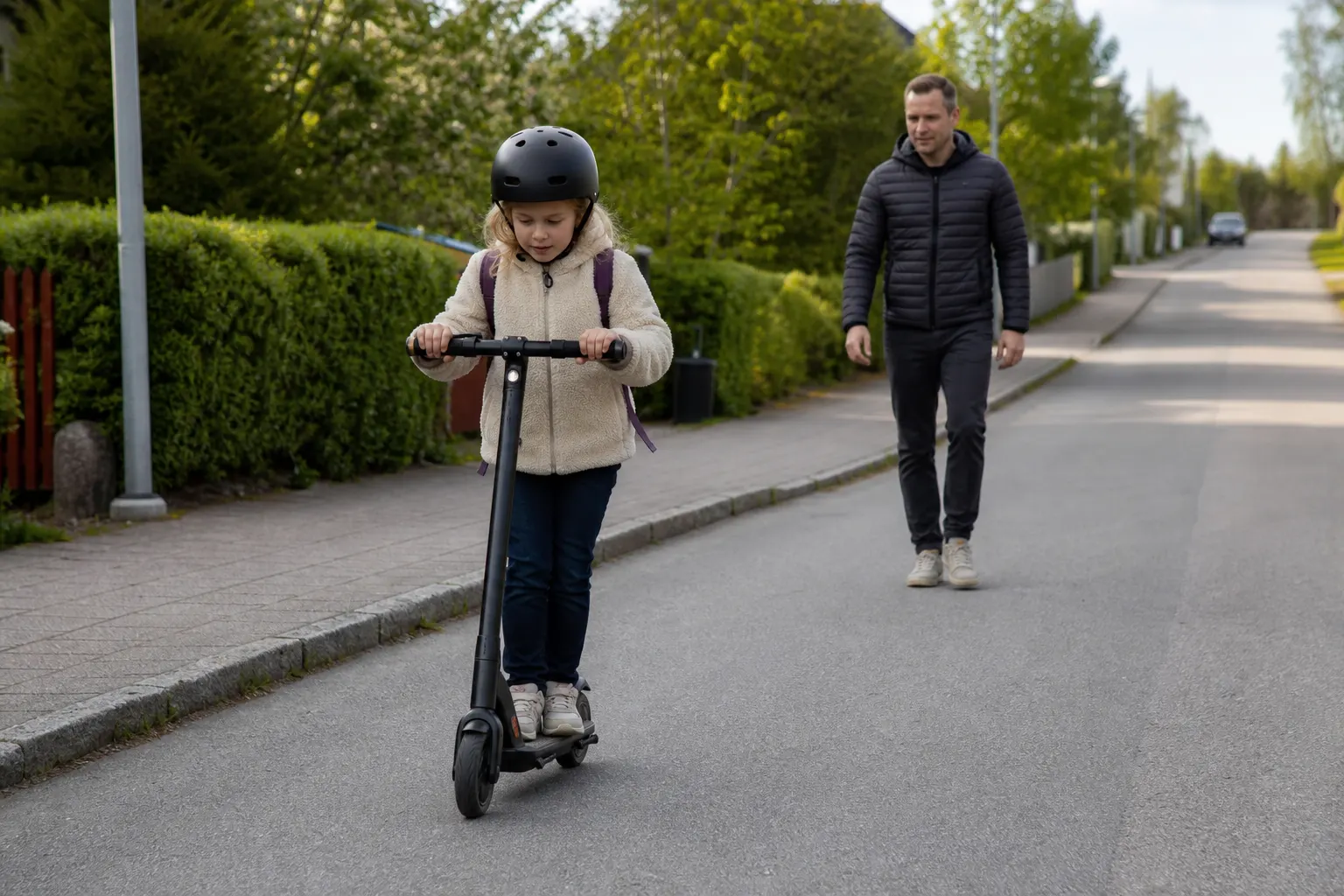 Barn med hjälm på elsparkcykel
