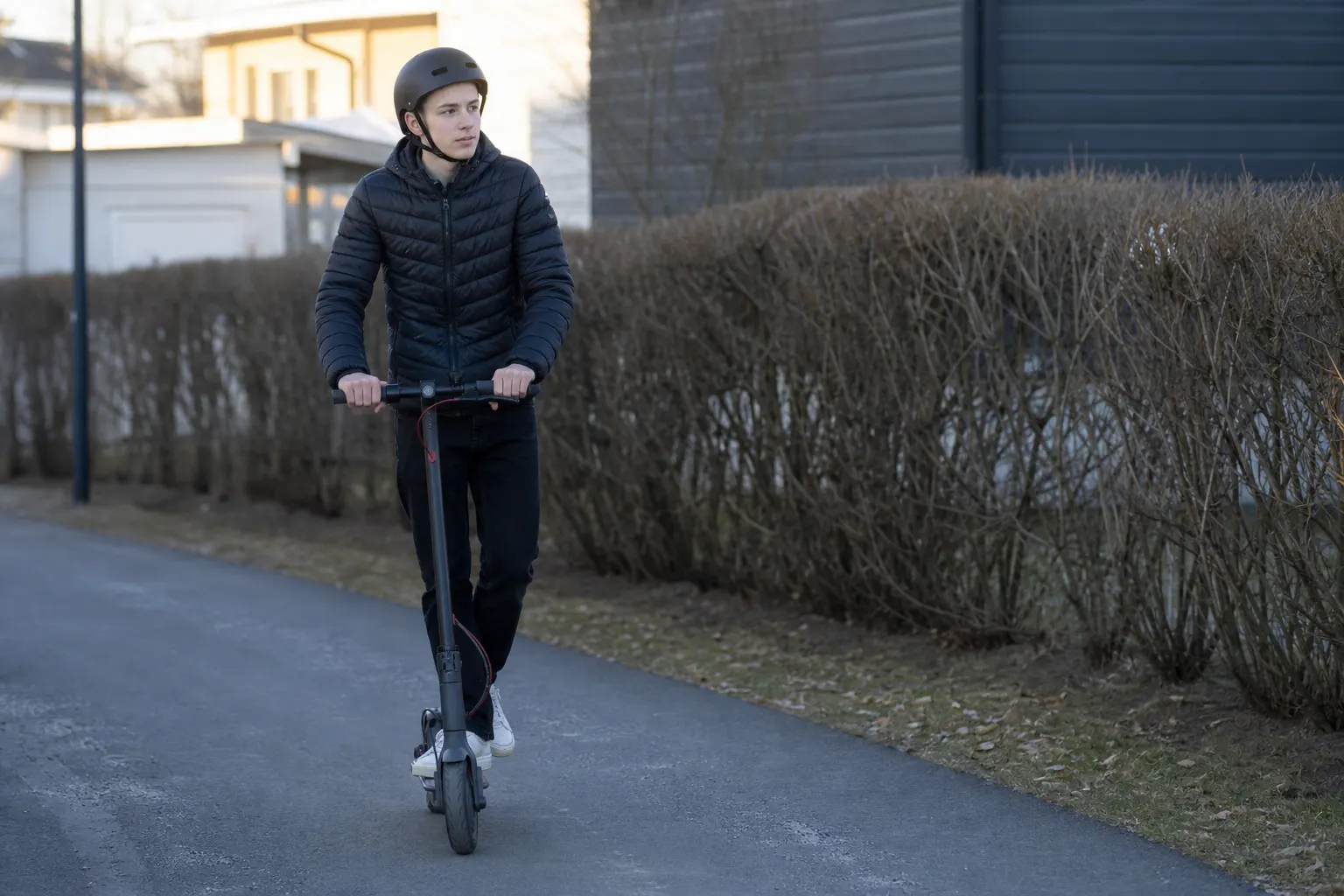 Ung person med elsparkcykel och hjälm